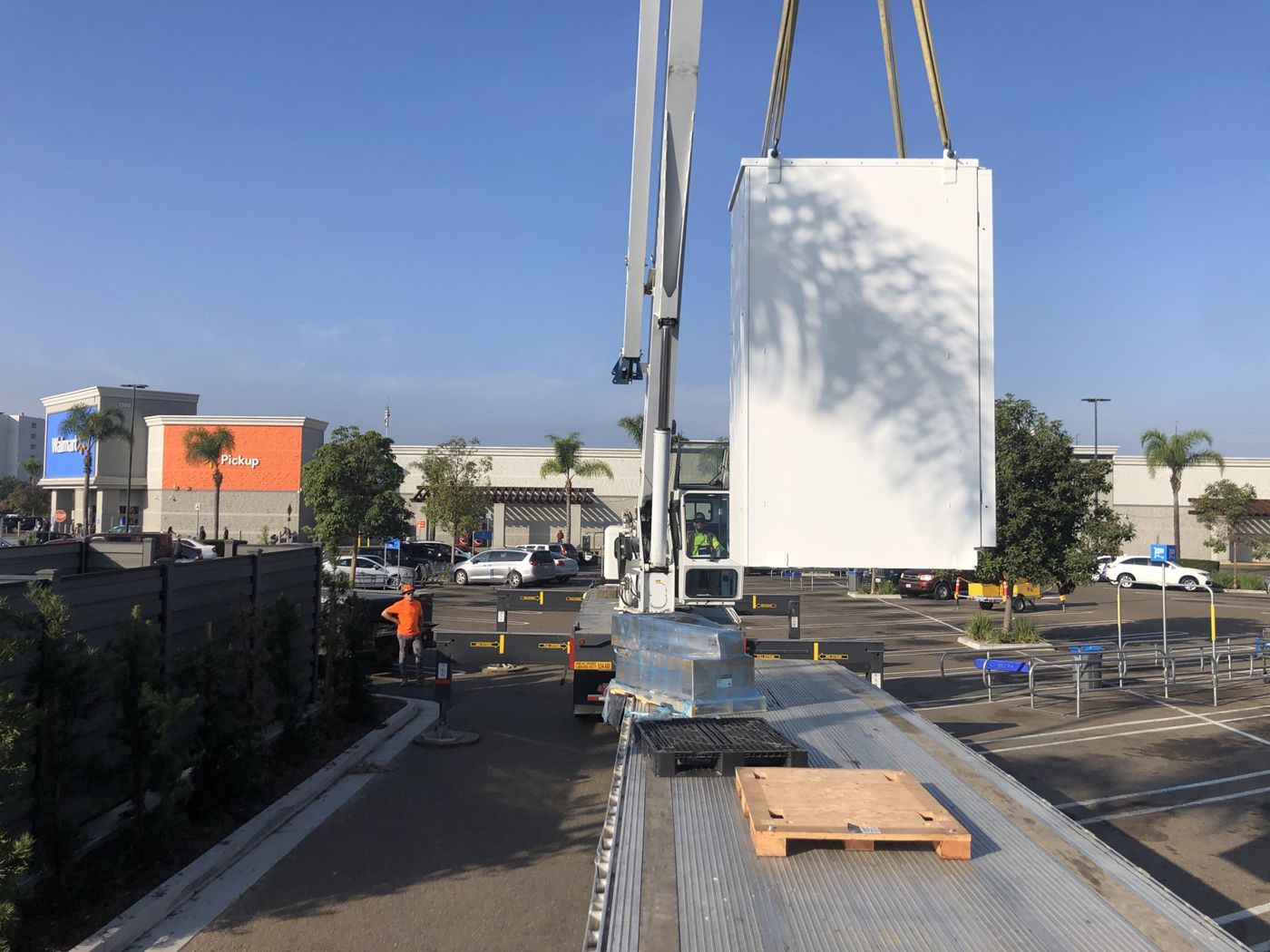 Battery cabinet lifted by crane from a flatbed truck