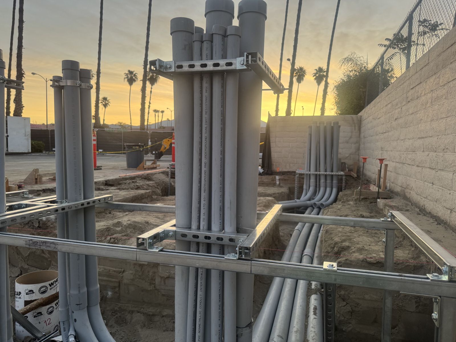 Prefabricated conduit risers on strut racks at sunset