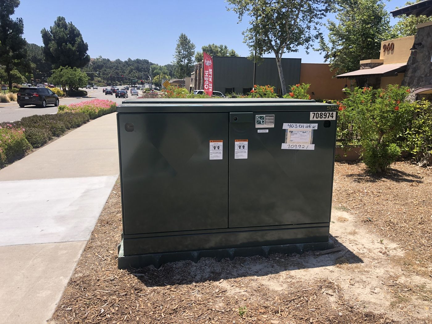 Utility pad-mounted switch set beside a sidewalk